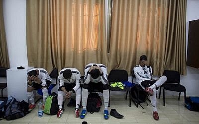 In this Friday Feb. 7, 2014 photo, Wadi al-Nees players sit dejected after losing first of a league game at a stadium in Hebron, West Bank. (photo credit: AP Photo/Dusan Vranic)