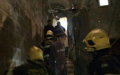 Firefighters attempt to reach people trapped inside a collapsed building in Acre after a gas explosion (photo credit: Ichud Hatzalah/Spokesman)
