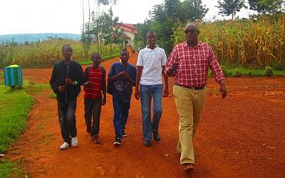Jean-Claude Nkulikiyimfura, right, the director of the Agahozo-Shalom Youth Village, walking with students returning from lunch. (photo credit:  JTA/Ben Sales)