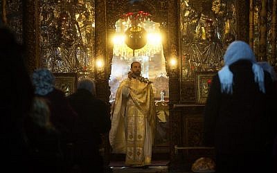 A Christian priest and worshipers attend a Sunday mass at the Church of the Nativity, in the West Bank biblical town of Bethlehem (photo credit: AFP/File Menahem Kahana)