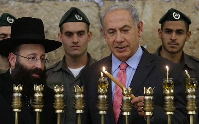 Prime Minister Benjamin Netanyahu lights the Hanukia together with Rabbi of the Western Wall Shmuel Rabinovitch, at the Western Wall on the second night of the Jewish holiday of Hannuka. November 28, 2013. (photo credit: Marc Israel Sellem/Pool/Flash90) Prime Minister Benjamin Netanyahu lights the Hanukia together with Rabbi of the Western Wall Shmuel Rabinovitch, at the Western Wall on the second night of the Jewish holiday of Hannuka. November 28, 2013. (photo credit: Marc Israel Sellem/Pool/Flash90)
