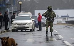 An unidentified armed man patrols a square in front of the airport in Simferopol, Ukraine, Friday, February 28, 2014. (photo credit: AP/Andrew Lubimov)