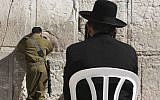 Could these two be in the same unit? In this illustrative photo of an Israeli soldier and ultra-Orthodox man pray at the Western Wall on February 2. (photo credit: Nati Shohat/FLASH90)