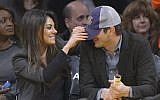 Actress Mila Kunis playfully pulls down the hat of actor Ashton Kutcher before a Los Angeles Lakers' NBA basketball game against the Utah Jazz,  January 3, 2014, in Los Angeles. (AP/Mark J. Terrill)