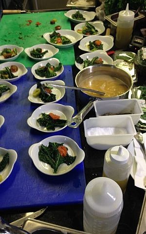 Sea bream on a bed of broccoli rabe and roasted tomatoes with a side of kale (photo credit: Jessica Steinberg/Times of Israel)