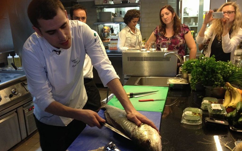 Chef Orel Kimchi demonstrates how to fillet a fresh sea bream (photo credit: Jessica Steinberg/Times of Israel) Chef Orel Kimchi demonstrates how to fillet a fresh sea bream (photo credit: Jessica Steinberg/Times of Israel)