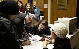 Rabbi Moshe Shulman of Young Israel of St Louis, signs the postnup with his wife, Baila Shulman. (photo credit: JTA/Rori Picker Neiss)