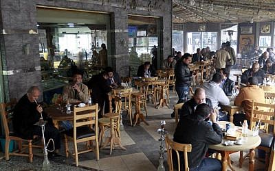 (Men smoke water pipes at a cafe in the Jordanian capital Amman on February 3, 2014. (photo credit: AFP/Khalil Mazraawi) 