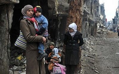 Residents of the besieged Yarmouk Palestinian refugee camp wait to leave the camp, on the southern edge of the Syrian capital Damascus, Syria, Feb. 4, 2014 (photo credit: AP/SANA)