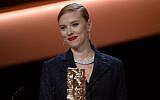 Scarlett Johansson smiles on stage after being awarded with an honorary award during the 39th edition of the Cesar awards ceremony in Paris on February 28, 2014 (photo credit: AFP/Martin Bureau)