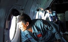 Military personnel scanning the sea aboard a Vietnamese Air Force aircraft taking part in a search mission for a missing Malaysia Airlines aircraft, somewhere between Malaysia's east coast and southern Vietnam on Saturday. (photo credit: AFP/Thanh Nien Newspaper)