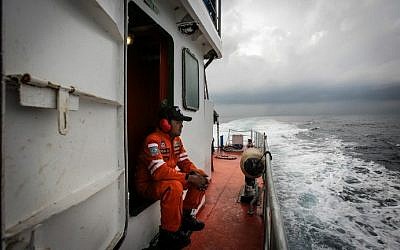 Indonesian national search and rescue agency personel watch over high seas during a search operation for missing Malaysia Airlines flight MH370 in the Andaman Sea on March 15, 2014 (Photo credit: Chaideer Mahyuddin /AFP)