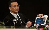 Malaysian Minister of Defense and Acting Transport Minister Hishammuddin Hussein shows pictures of possible debris during his statement on the missing Malaysia Airlines flight MH370 at the Putra World Trade Center (PWTC) in Kuala Lumpur on March 26, 2014. (photo credit: AFP Mohd Rasfan)