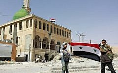 Pro-government fighters hold the Syrian flag as they pose for a photo in the village of al-Sahel, near Yabroud on March 4, 2014. (photo credit: AFP/STR)