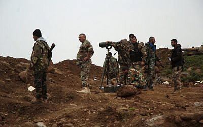 Syrian forces hold a position during fighting against rebels in the town of Zara, in the province of Homs, on March 8, 2014. (photo credit: AFP/STR)