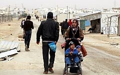 A Syrian refugee woman pushes a stroller at the Zaatari refugee camp, near the Jordanian border with Syria, on March 8, 2014. (AFP/Khalil Mazraawi)