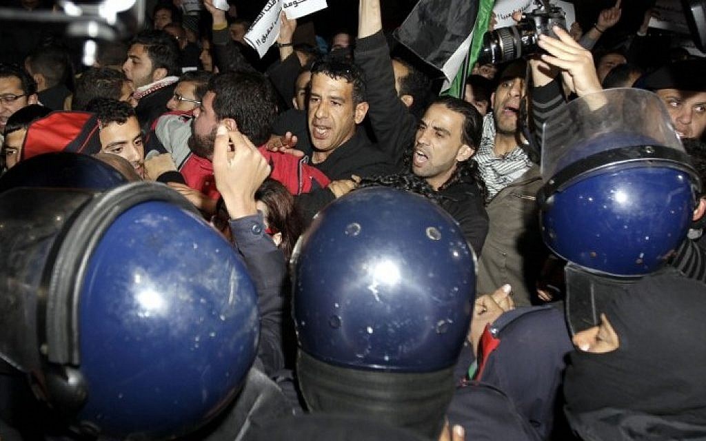 Riot police try to control several hundred angry Jordanians as they protest in front of the Israeli Embassy in Amman, Jordan, on Monday (photo credit: AFP/Khalil Mazraawi)