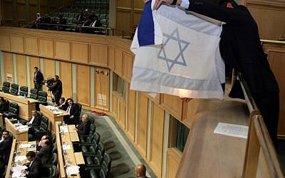 A Jordanian activist prepares to set a makeshift Israeli flag ablaze during a session of Jordan's House of Representatives on March 11, 2014 (photo credit: AFP PHOTO/STR)