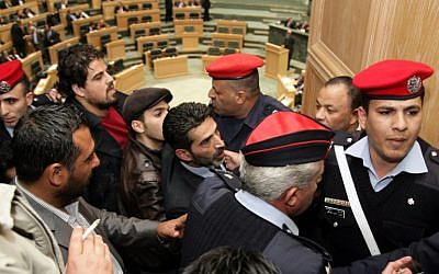 Security forces detain Jordanian activists who tried to set ablaze a makeshift Israeli flag during a session of Jordan's House of Representatives on March 11, 2014. (photo credit: AFP/STR)