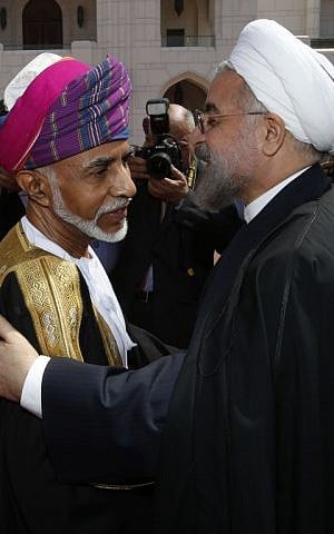 Omani leader Sultan Qaboos bin Said (L) greets Iranian President Hassan Rouhani upon his arrival in Muscat on March 12, 2014. (photo credit: AFP/Mohammed Mahjoub)