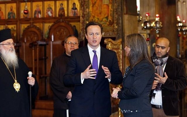 British Prime Minister David Cameron, center, talks to officials as he visits the Church of the Nativity in the West Bank town of Bethlehem, on March 13, 2014. (photo credit: AFP/POOL/THOMAS COEX) British Prime Minister David Cameron, center, talks to officials as he visits the Church of the Nativity in the West Bank town of Bethlehem, on March 13, 2014. (photo credit: AFP/POOL/THOMAS COEX)