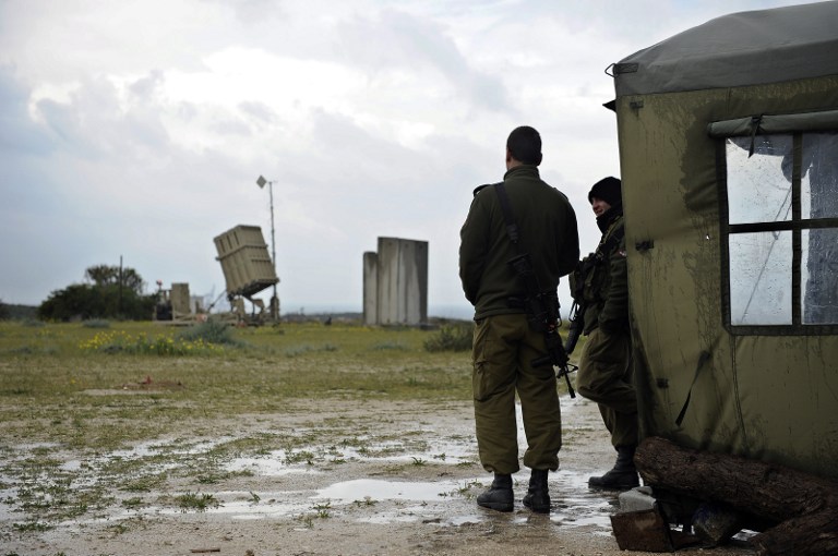 Two Israeli soldiers stand near an Iron Dome battery near the southern Israeli city of Ashkelon on March 13, 2014. (photo credit:AFP/DAVID BUIMOVITCH) Two Israeli soldiers stand near an Iron Dome battery near the southern Israeli city of Ashkelon on March 13, 2014. (photo credit:AFP/DAVID BUIMOVITCH)