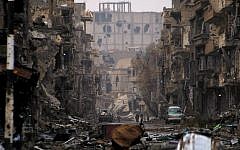 A photo taken on January 4, 2014, shows Syrians walking along a severely damaged road in the northeastern city of Deir Ezzor (Ahmad Aboud/AFP)