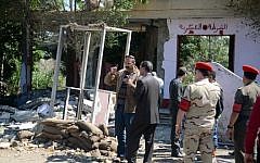 Egyptian soldiers and officials inspect the site where gunmen killed six soldiers at a Cairo checkpoint on March 15, 2014. (photo credit: AFP/AHMED GAMEL)