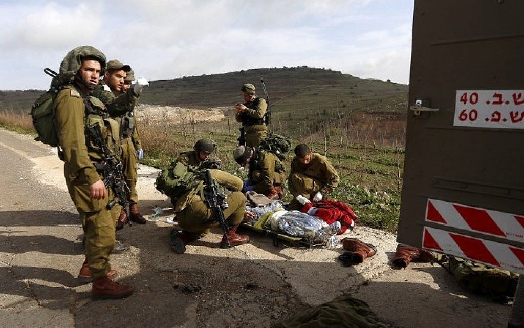 IDF soldiers prepare to evacuate a comrade injured in a blast on the border with Syria, near the village of Majdal Shams on Tuesday, March 18, 2014 (photo credit: AFP/Jalaa Marey) IDF soldiers prepare to evacuate a comrade injured in a blast on the border with Syria, near the village of Majdal Shams on Tuesday, March 18, 2014 (photo credit: AFP/Jalaa Marey)