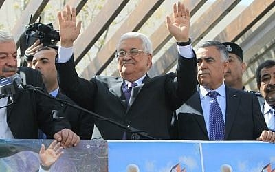 Palestinian Authority President Mahmoud Abbas waves to his supporters following his trip to Washington, DC, on Thursday, March 20, 2014, in the West Bank city of Ramallah (photo credit: AFP/Abbas Nomani)