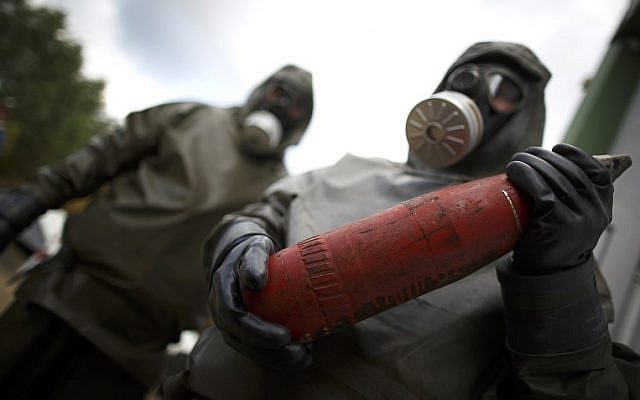Employees in protective gear holding a dummy grenade during a demonstration at a chemical weapons disposal facility in Munster, northern Germany, October 30, 2013 (AFP PHOTO/ Phillip Guelland) Employees in protective gear holding a dummy grenade during a demonstration at a chemical weapons disposal facility in Munster, northern Germany, October 30, 2013 (AFP PHOTO/ Phillip Guelland)