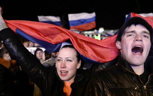 People sing the Russian national anthem as they celebrate in Simferopol's Lenin Square on March 16, 2014 after exit polls showed a huge majority of voters in Ukraine's Crimea region supported union with Russia. (photo credit: AFP photo / Dimitar Dilkoff) People sing the Russian national anthem as they celebrate in Simferopol's Lenin Square on March 16, 2014 after exit polls showed a huge majority of voters in Ukraine's Crimea region supported union with Russia. (photo credit: AFP photo / Dimitar Dilkoff)