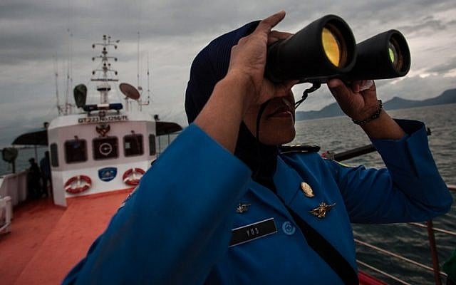 A member of Indonesia's National Search and Rescue looks over horizon during a search in the Andaman sea area around northern tip of Indonesia's Sumatra island for the missing Malaysian Airlines flight MH370 on March 17, 2014. (photo credit:AFP/ CHAIDEER MAHYUDDIN)