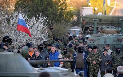Pro-Russian militiamen cordon off as Russian soldiers storm the Ukrainian military airbase in Belbek near the Crimean city of Sevastopol on Saturday, March 22, 2014 (photo credit: AFP/Viktor Drachev)