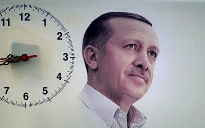 A poster showing Turkish Prime Minister Recep Tayyip Erdogan is seen next to a hanging clock during a rally of the Justice and Development Party (AKP) in the Maltepe district at the Asia side of Istanbul on Saturday, March 29, 2014 (photo credit: AFP/Ozan Kose)