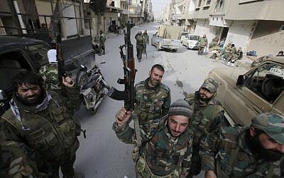 Pro-government forces stand on a street in the Syrian town of Yabroud on March 16, 2014 after they seized full control of the rebel bastion in the strategic Qalamun region near the Lebanese border. (photo credit: Topshots/AFP/Joseph Eid)