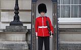 A guard outside London's Buckingham Palace (photo credit: CC BY-SA CatholicYouthWork.com/Flickr)