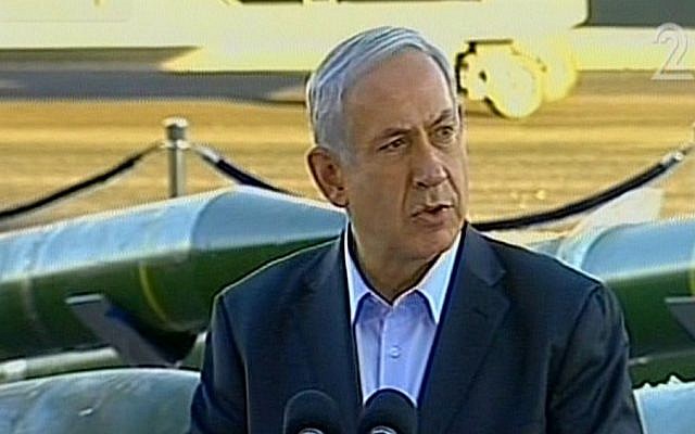 Prime Minister Benjamin Netanyahu speaks at an Israel naval base in the southern port city of Eilat on March 10, 2014. In the background, weapons seized on board the Klos-C can be seen on display. (screen capture, Channel 2)