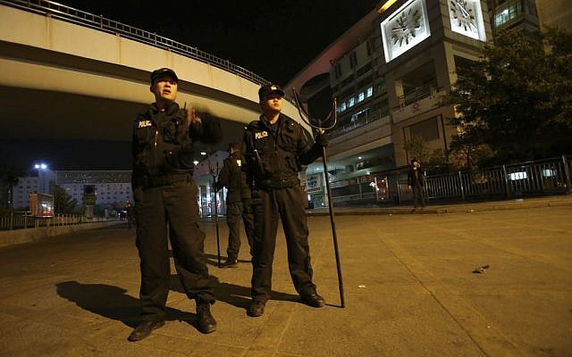 Policemen guard outside a railway station after an attack by knife wielding men left some 27 people dead in Kunming, in southwestern China's Yunnan province, Saturday March 1, 2014 (photo credit: AP) Policemen guard outside a railway station after an attack by knife wielding men left some 27 people dead in Kunming, in southwestern China's Yunnan province, Saturday March 1, 2014 (photo credit: AP)