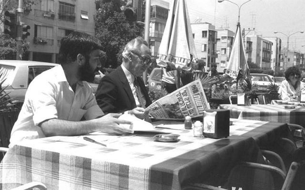 Shimon Peres reads a newspaper at a Tel Aviv cafe (photo credit: GPO)