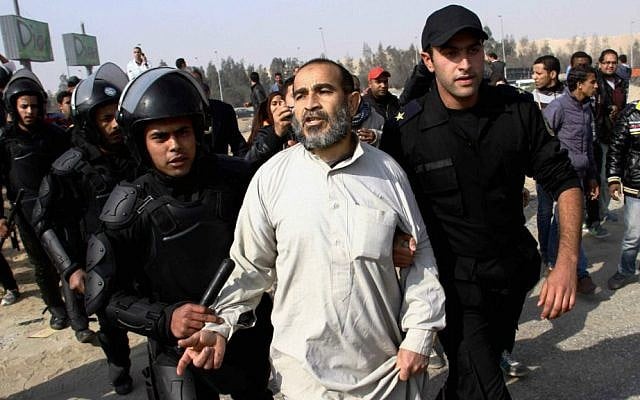 Illustrative: In this Wednesday, January 8, 2014 file photo, Egypt's riot police officers arrest a man, center, following clashes between supporters of Egypt's ousted president Mohammed Morsi and riot police in Cairo, Egypt. (photo credit: AP Photo/Ahmed Gomaa, File) Illustrative: In this Wednesday, January 8, 2014 file photo, Egypt's riot police officers arrest a man, center, following clashes between supporters of Egypt's ousted president Mohammed Morsi and riot police in Cairo, Egypt. (photo credit: AP Photo/Ahmed Gomaa, File)