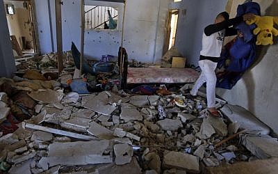 Personal belongings are removed from inside the home of Hamza Abu el-Hija, where he was killed by Israeli troops, in the West Bank refugee camp of Jenin, Saturday, March 22, 2014. (photo credit: AP Photo/Mohammed Ballas)