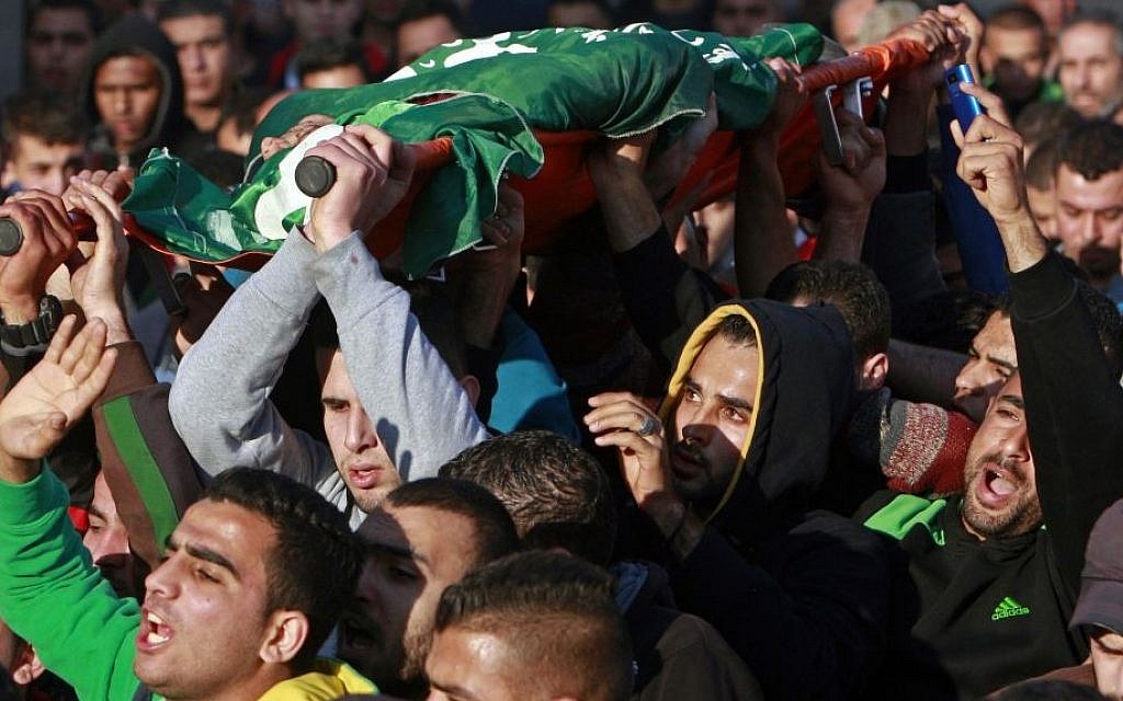 Palestinians carry the body of Hamza Abu al-Hija, who was killed in a raid by Israeli troops, during his funeral procession, in the West Bank refugee camp of Jenin, Saturday, March 22, 2014. (photo credit: AP Photo/Mohammed Ballas)