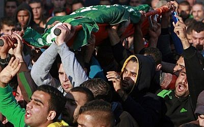 Palestinians carry the body of Hamza Abu al-Hija, who was killed in a raid by Israeli troops, during his funeral procession, in the West Bank refugee camp of Jenin, Saturday, March 22, 2014. (photo credit: AP Photo/Mohammed Ballas)