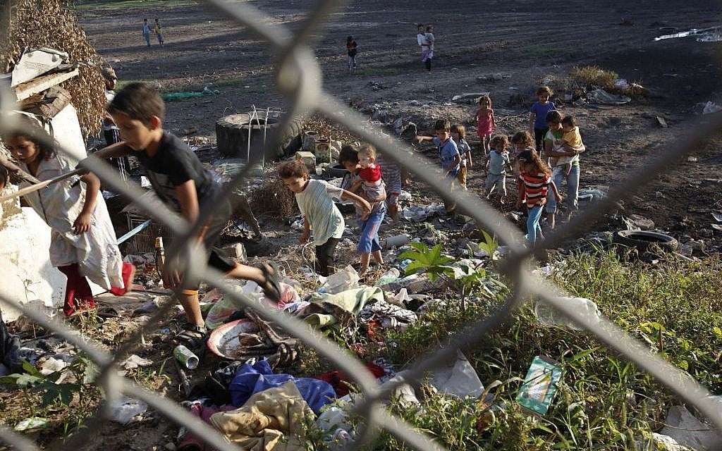 Palestinian children from the Alwadiya family play amid sewage and garbage behind the backyard of their family houses in Gaza City in the northern Gaza Strip.  (AP Photo/Adel Hana, File)