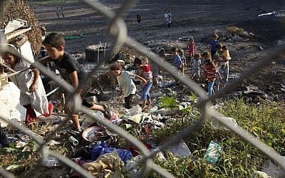 Palestinian children from the Alwadiya family play amid sewage and garbage behind the backyard of their family houses in Gaza City in the northern Gaza Strip.  (AP Photo/Adel Hana, File)