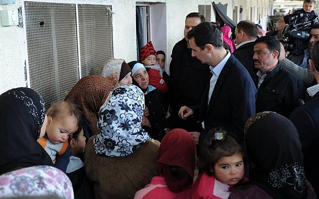 Syrian President Bashar Assad (center right), visits a shelter of internally displaced people in the Damascus suburb of Adra, Syria, on Wednesday, March 12, 2014. (photo credit: AP) Syrian President Bashar Assad (center right), visits a shelter of internally displaced people in the Damascus suburb of Adra, Syria, on Wednesday, March 12, 2014. (photo credit: AP)