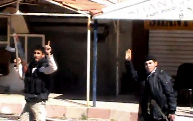 An image taken from video shows Syrian fighters holding their weapons as they gesture after seizing the predominantly Armenian Christian town of Kassab, Syria, March 23, 2014. (AP Photo/Shaam News Network via AP video) An image taken from video shows Syrian fighters holding their weapons as they gesture after seizing the predominantly Armenian Christian town of Kassab, Syria, March 23, 2014. (AP Photo/Shaam News Network via AP video)