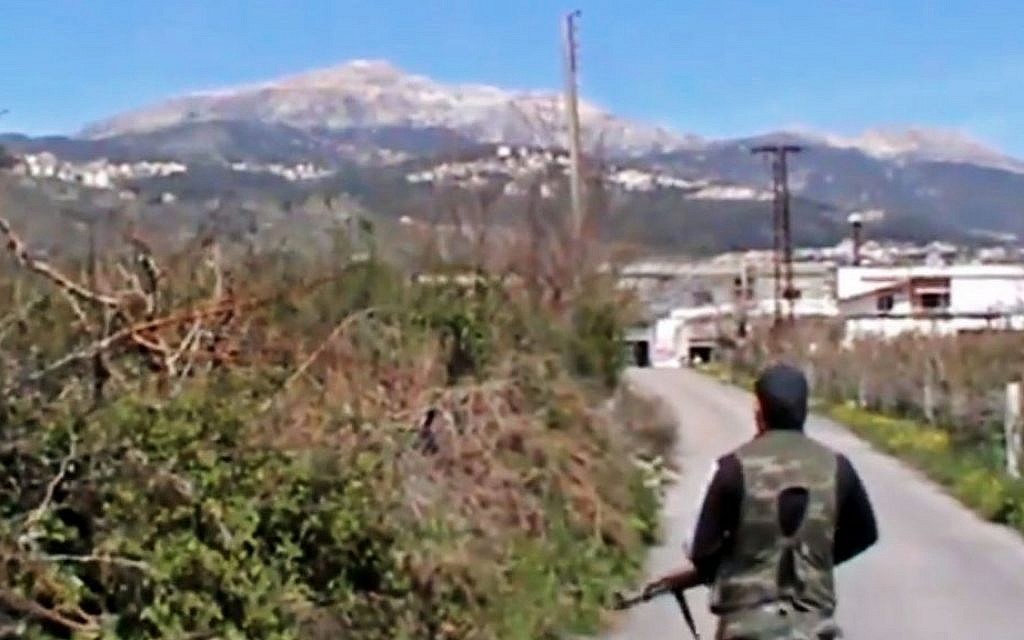 A Syrian fighter holds his weapon after seizing the predominantly Armenian Christian town of Kassab, Syria, near the Turkish border, on March 23, 2014. (AP Photo/Shaam News Network via AP video)