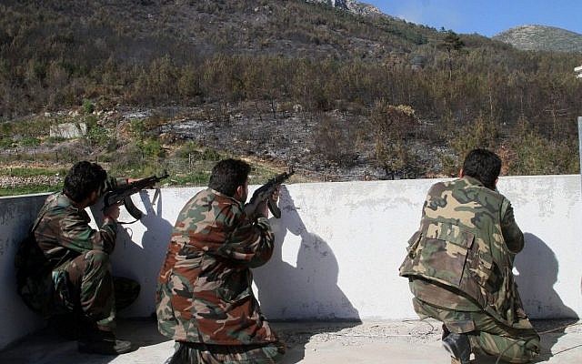 In this photo taken Thursday, March 27, 2014, Syrian government soldiers take position during clashes with rebels in Misherfeh in the province of Latakia, Syria. (photo credit: AP Photo) In this photo taken Thursday, March 27, 2014, Syrian government soldiers take position during clashes with rebels in Misherfeh in the province of Latakia, Syria. (photo credit: AP Photo)